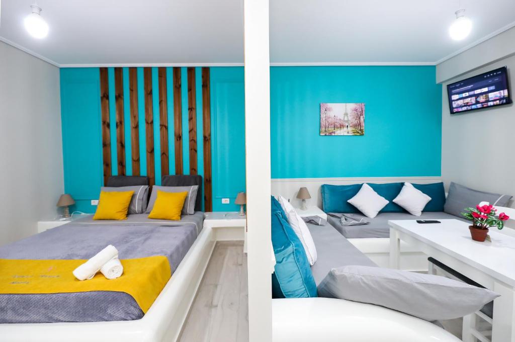 a bedroom with blue walls and a bed with yellow pillows at Guest House Narta in Vlorë