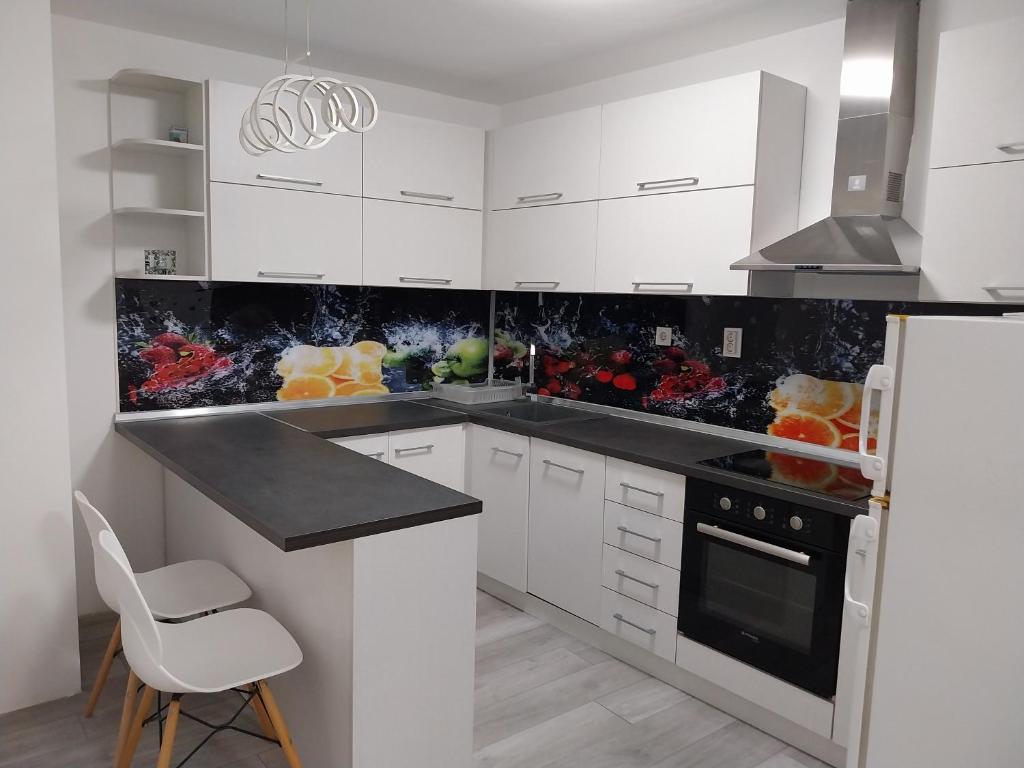 cocina con armarios blancos y encimera negra en DM Hostel and Apartments en Skopie