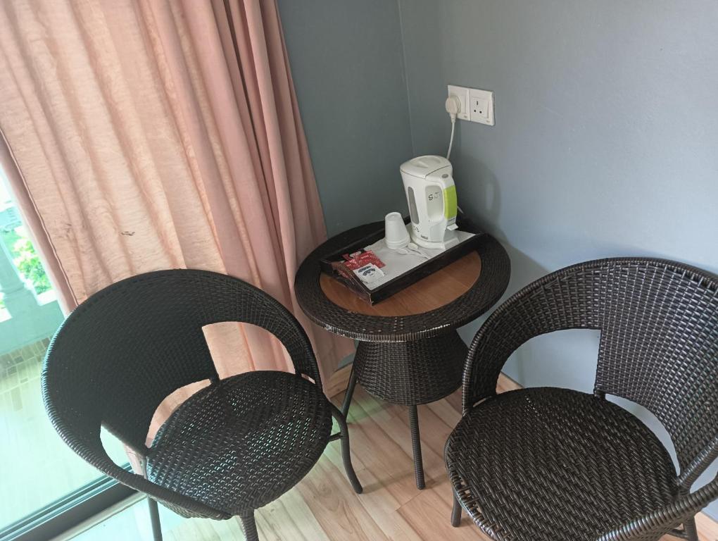 Sri Juliana Chalet في تاناه راتا: كرسيين وطاولة عليها صانع قهوة