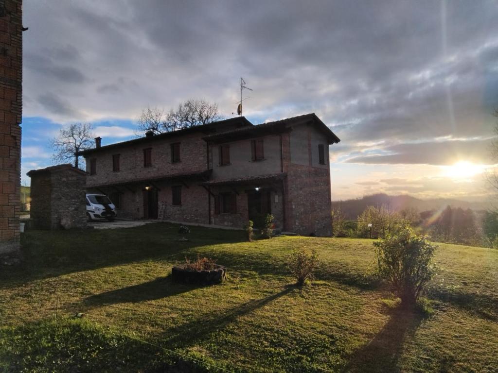 een huis op een heuvel met de zon op de achtergrond bij B&B del Fernè in Monte Ombraro