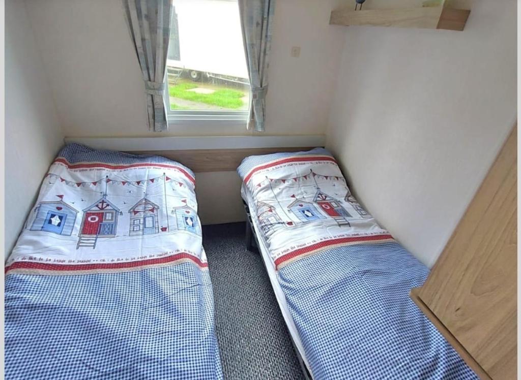 two beds in a small room with a window at Haven holiday park Cleethorpes beach in Cleethorpes