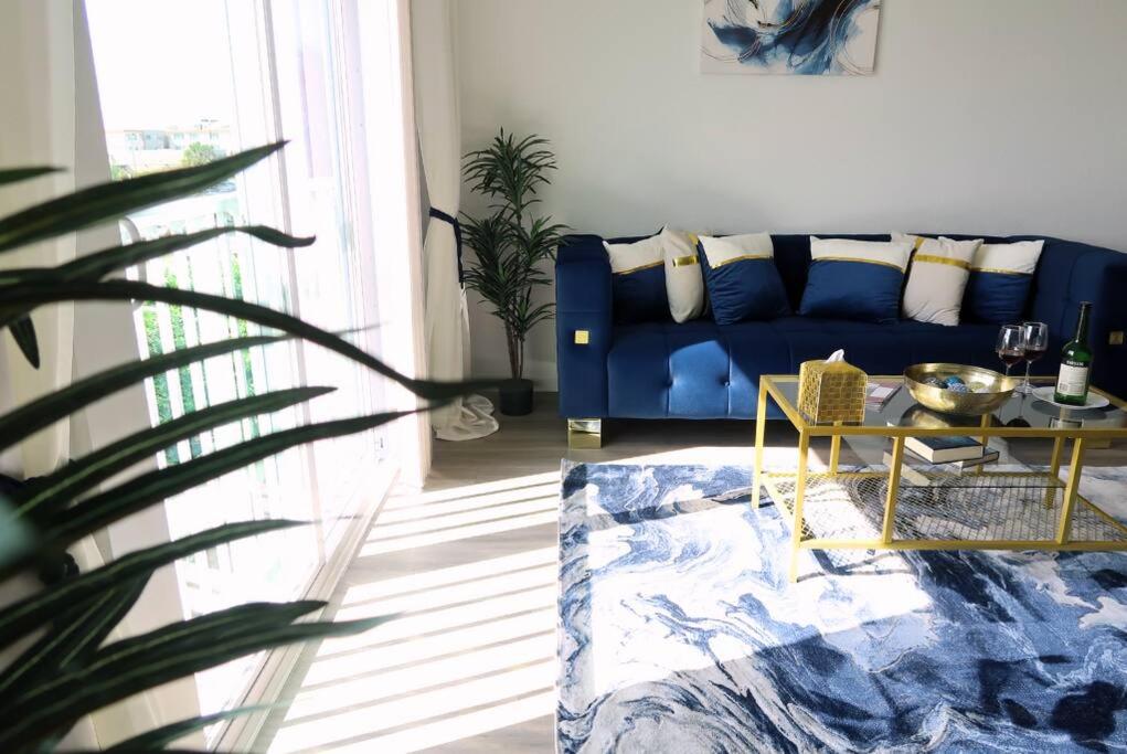 ein Wohnzimmer mit einem blauen Sofa und einem Tisch in der Unterkunft Beach Haven - 2BD Luxury Kings at Jax Beach in Jacksonville Beach