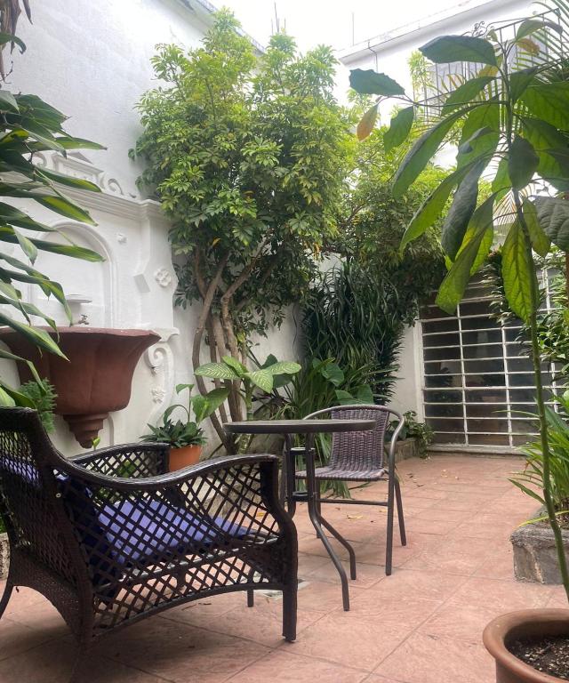 Guest House Casa Las Lajas في أنتيغوا غواتيمالا: فناء مع كرسيين وطاولة بالنباتات
