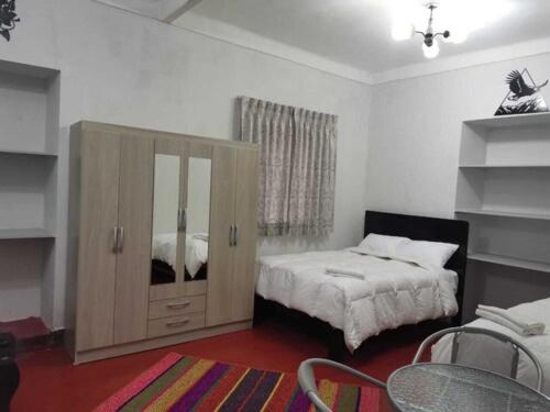 Un dormitorio con una cama y un armario. en Qosqollay Plaza de Armas en Cuzco