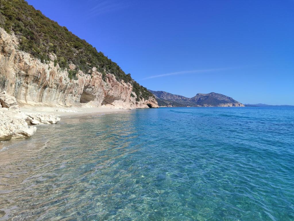 una playa de agua azul y una costa rocosa en Appartamento a 50 mt dal mare en Cala Gonone
