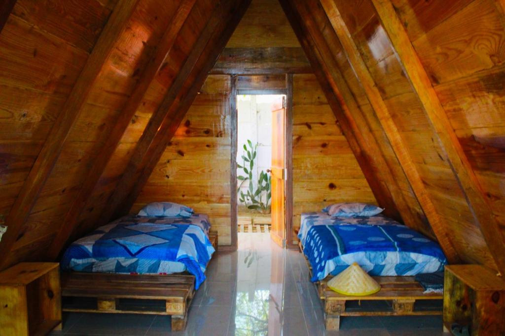dwa łóżka na poddaszu domku z bali w obiekcie Fundo El Cortarrama w mieście Talara