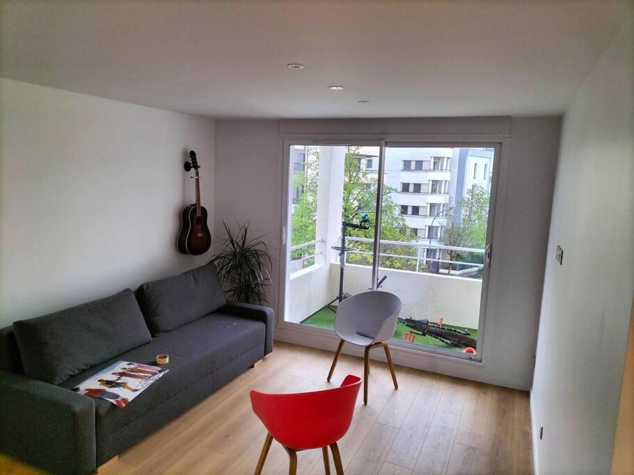 a living room with a couch and a red chair at T2 proche lac in Annecy