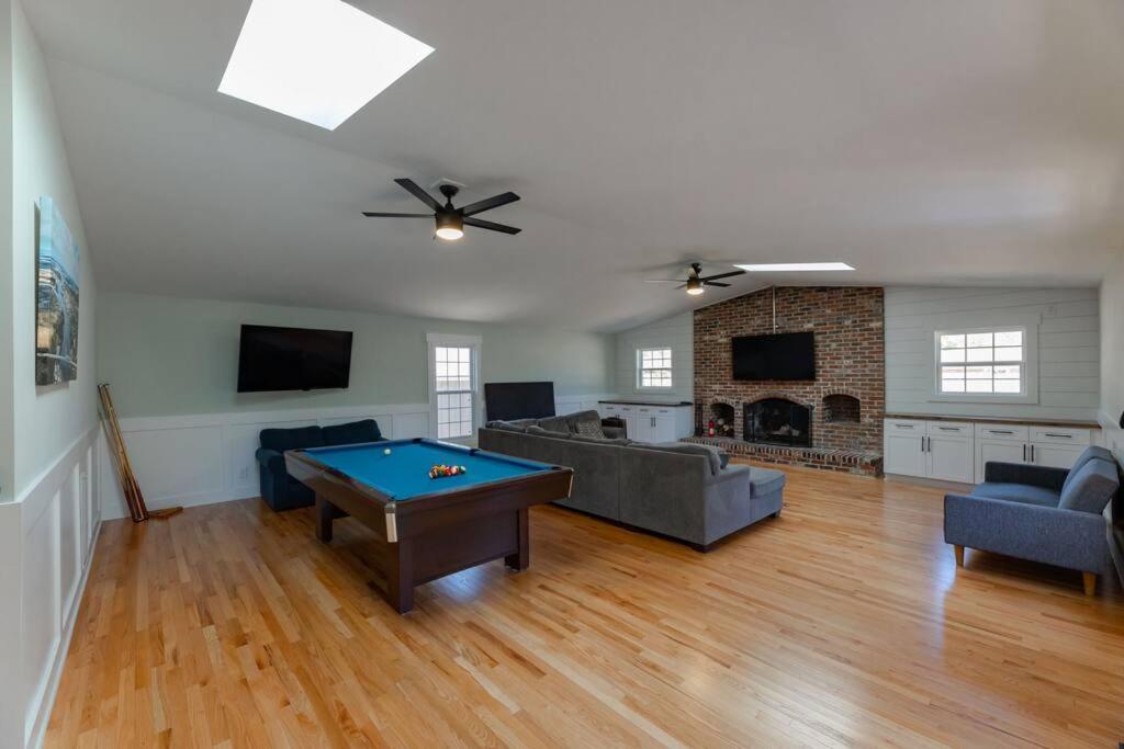 a living room with a pool table in it at Spacious Midtown Ranch- 10 min to Wrightsville in Wilmington