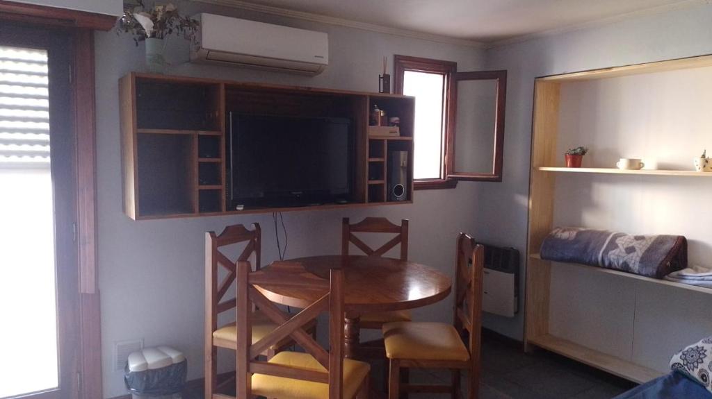 a small dining room with a table and a tv at Casa dique Pet Friendly in Tandil
