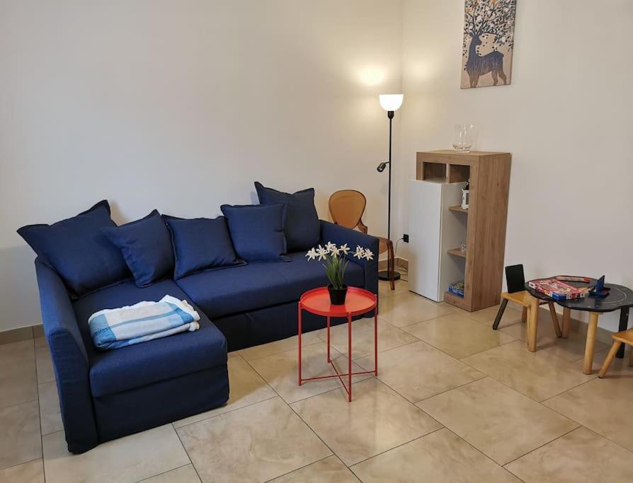 un salon avec un canapé bleu et une table dans l'établissement INES HOME tra lago e montagna - Lago d'Iseo, à Pisogne