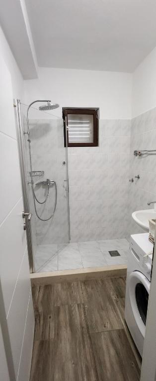 y baño blanco con ducha y aseo. en Apartments Kapetanovi Dvori, en Trogir