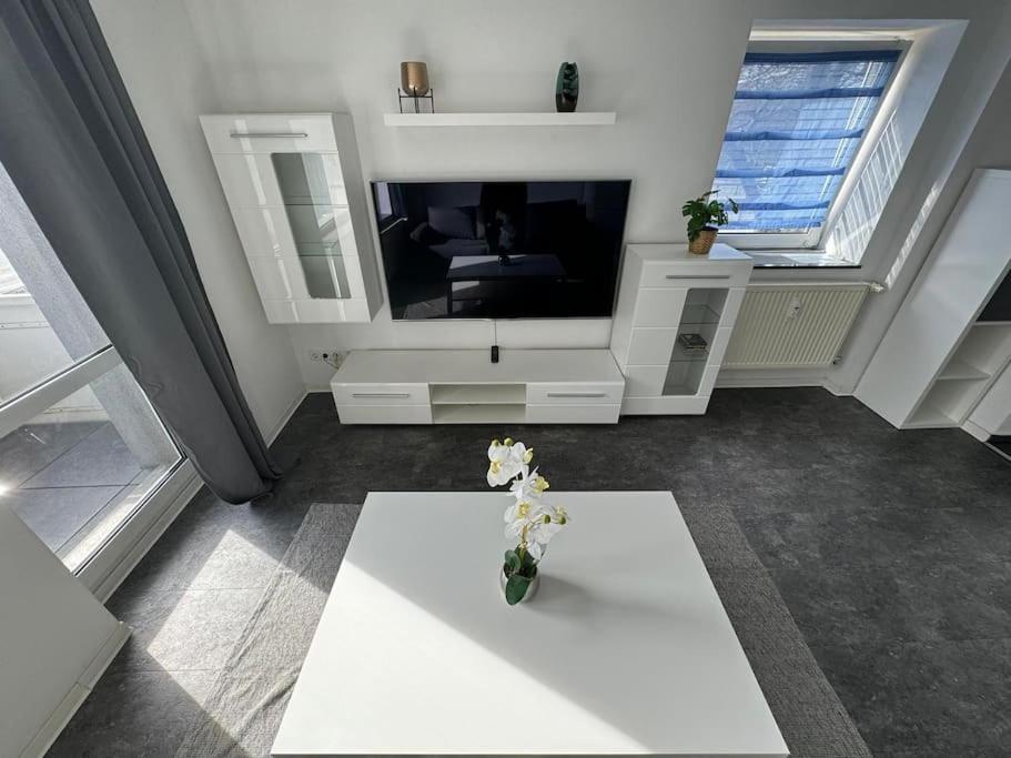 Gemütliches 2-Raum-Apartment في شيمنيتز: غرفة معيشة مع تلفزيون و إناء من الزهور على طاولة
