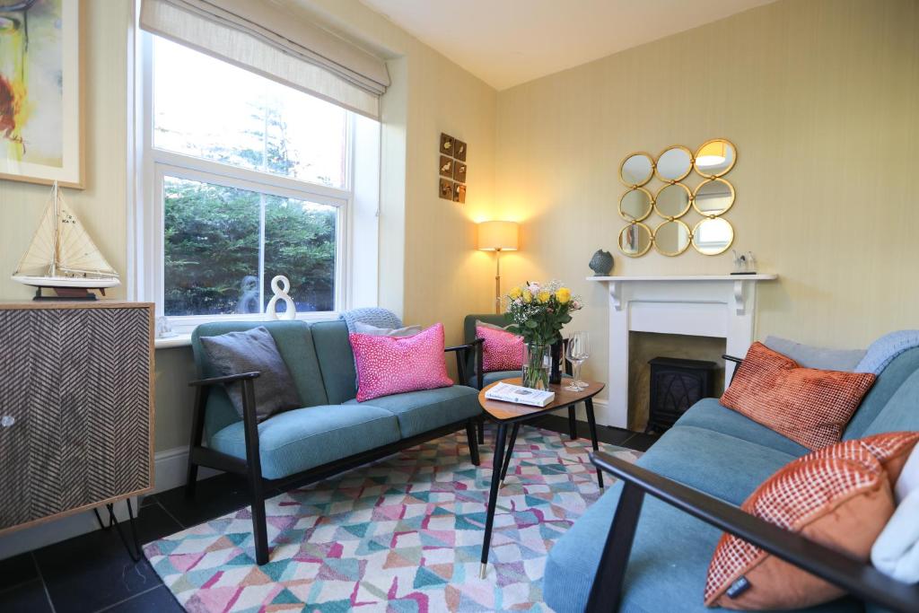 a living room with two couches and a fireplace at Ferndale Cottage in Lynmouth