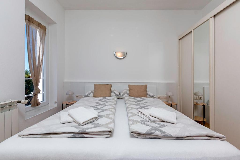 1 dormitorio blanco con 1 cama blanca grande con almohadas en Apartments Antic, en Pula