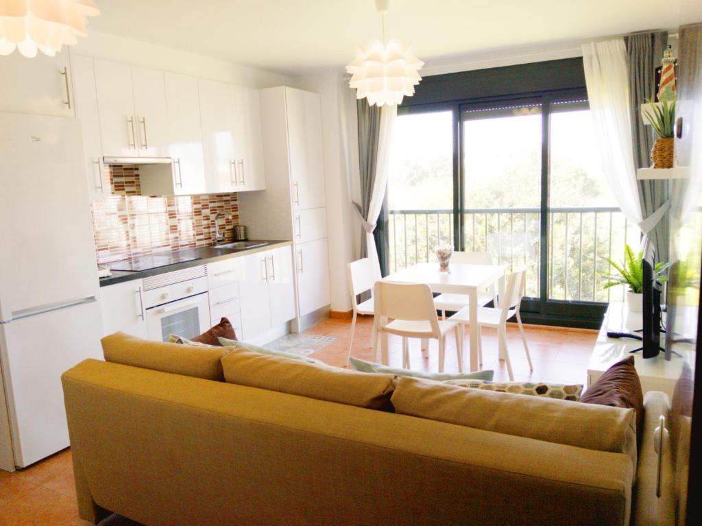 a living room with a couch and a kitchen with a table at Piso ESPAZ in Isla de Arosa