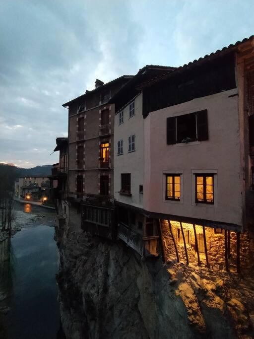 un bâtiment assis sur une falaise à côté d'une rivière dans l'établissement Maison suspendue avec jacuzzi privatif, à Pont-en-Royans