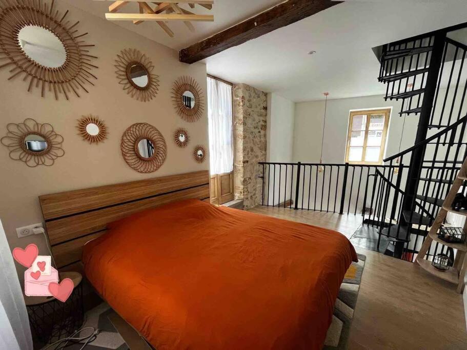 a bedroom with a bed and mirrors on the wall at Maison suspendue avec jacuzzi privatif in Pont-en-Royans
