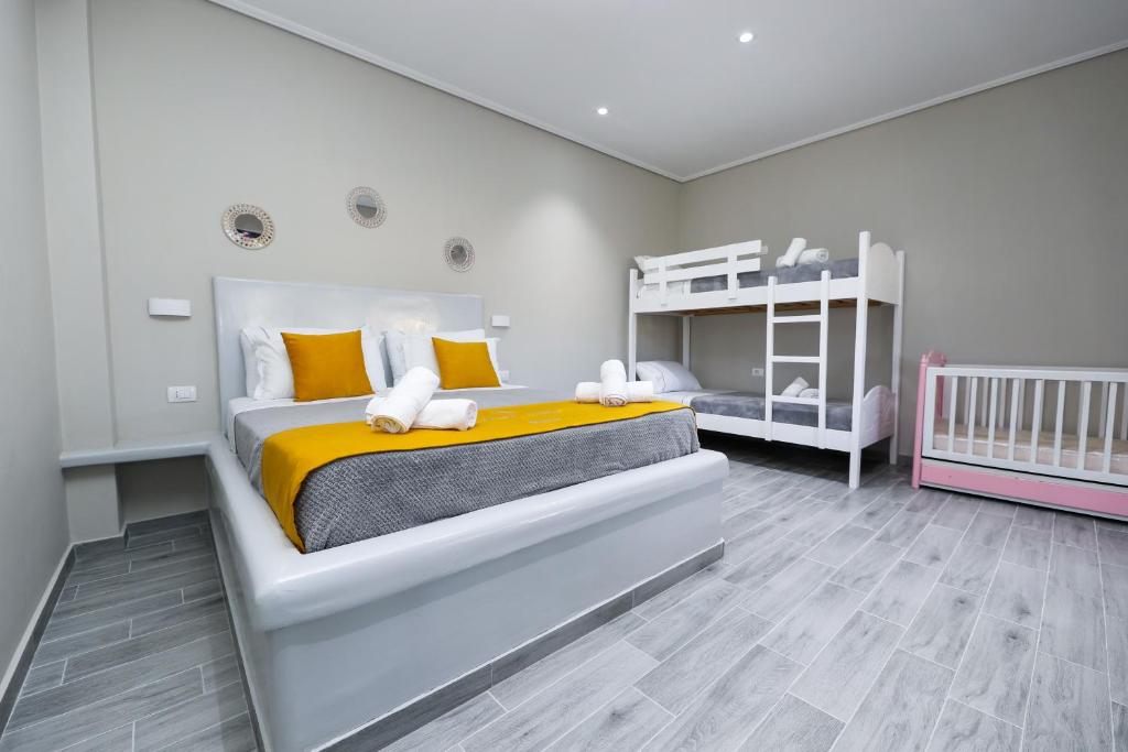 a bedroom with a large bed and a crib at Guest House Narta in Vlorë