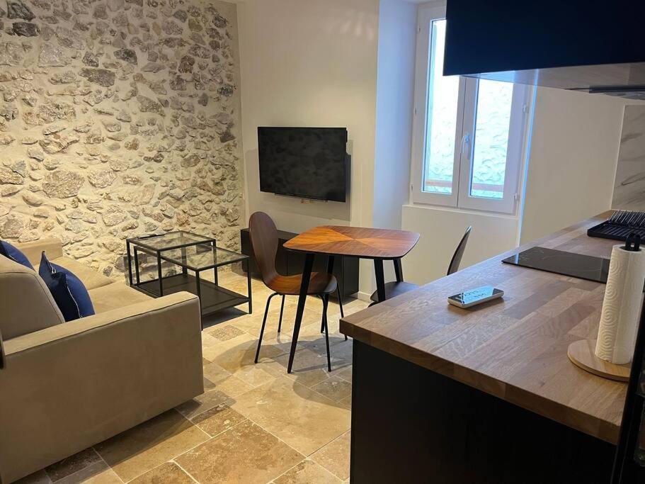 sala de estar con sofá y mesa en MORINGA - New unit for 2 AC close to beach, en Antibes