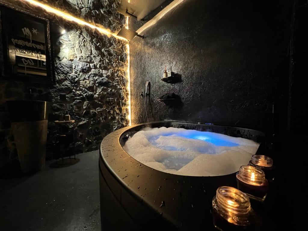 a dark bathroom with a bath tub with lights at DoorMat#13 Black Mirror in Thessaloniki