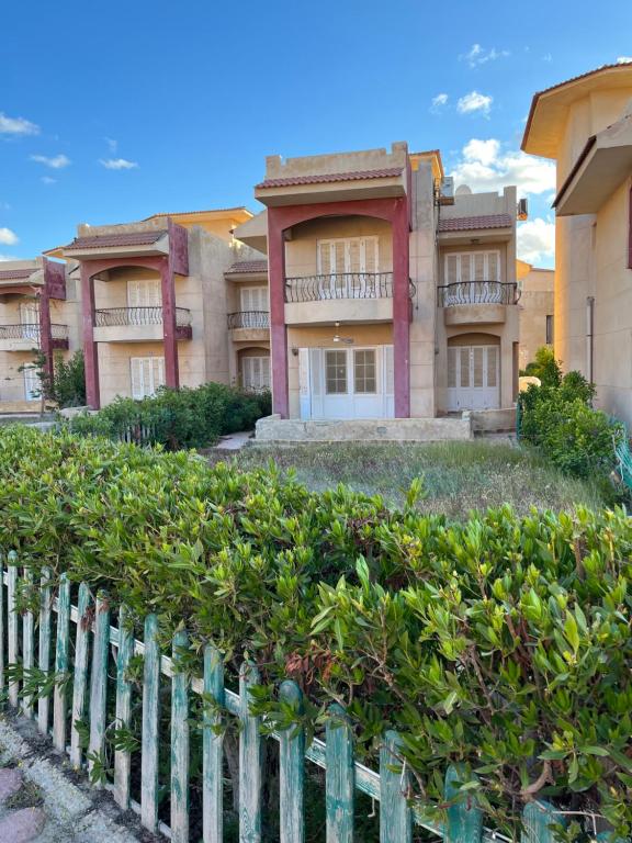 een huis met een hek ervoor bij Luxury Inn: 3BR Villa in North Coast Area 61 Km in Dawwār ‘Abd Allāh