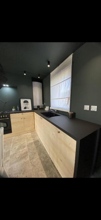 a kitchen with a black counter top and a window at Appartement T2 au calme in Toulon