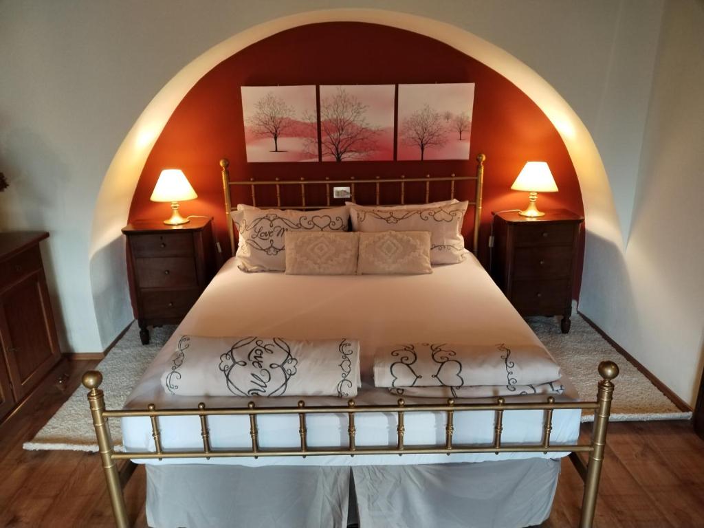 a bedroom with a large bed with two lamps at Little Country House in Bellano