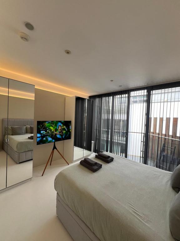 a bedroom with a large bed and a flat screen tv at Casa Olmi in Shoreditch in London