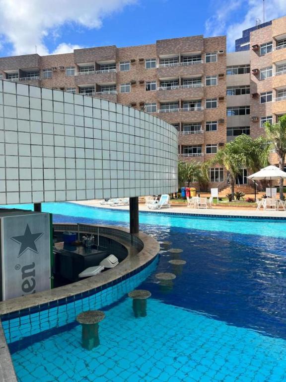 a swimming pool in front of a large building at Gran Lençóes Flat Residence in Barreirinhas