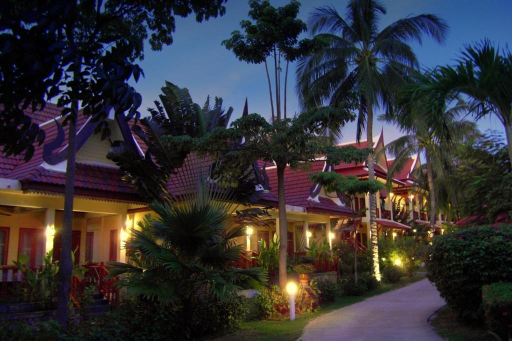 een resort met palmbomen en verlichting bij Palm Village in Rawai Beach