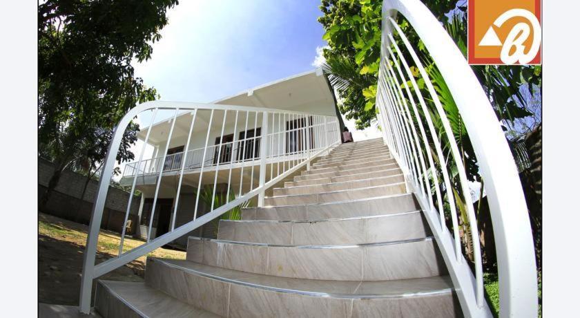 a staircase with a metal railing in front of a building at Oudarya Guest in Polonnaruwa