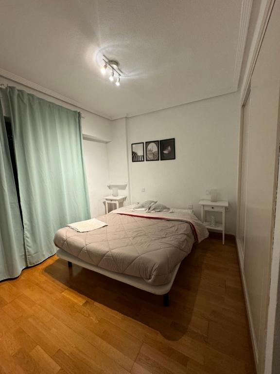a white bedroom with a bed and a window at Apartamento funcional Arrixaca in El Palmar