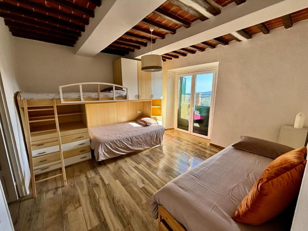 een slaapkamer met 2 bedden en een groot raam bij Casa di Nonno Gio' - Tuscan ToBe in Santa Fiora