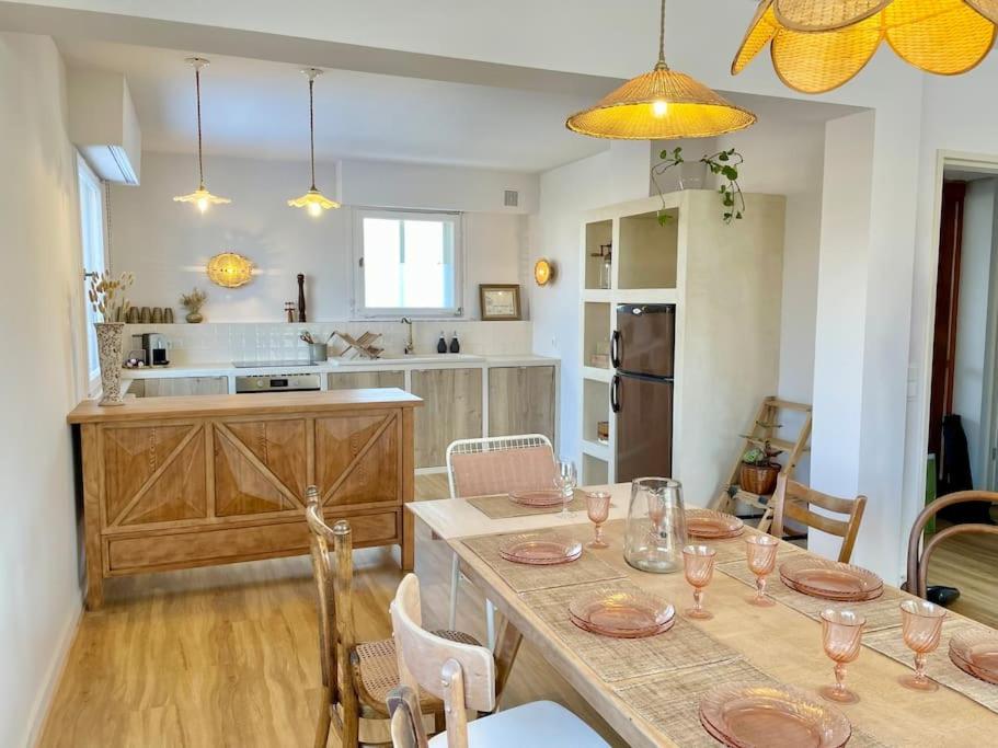 een keuken met een tafel met wijnglazen erop bij Maison individuelle 100 m2, jardin et parking privé in Colmar