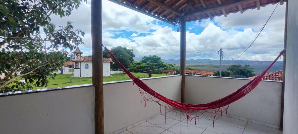 un'amaca sul balcone di una casa di Suítes Dona Maria de Tino a Milho Verde