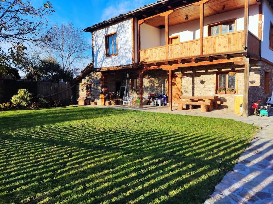 una casa con un gran césped delante de ella en Stone house (Каменната къща), en Leshten