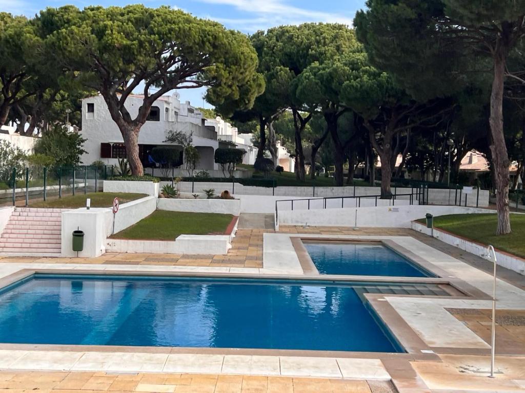 a swimming pool in a yard with trees at Casa da Aldeia in Olhos de Água