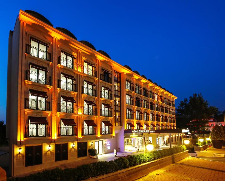 un gran edificio por la noche con luces encendidas en Gonluferah City Hotel en Bursa