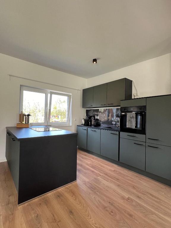 a large kitchen with gray cabinets and a counter top at HOME OF VACATION - Ferienhaus bei Celle nähe Hannover - FREE WIFI & Netflix in Adelheidsdorf