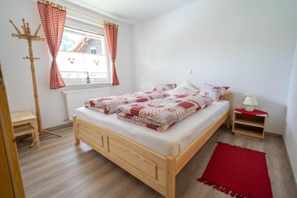 Schlafzimmer mit einem Bett mit roter Bettwäsche und einem Fenster in der Unterkunft Gorski biser in Mojstrana