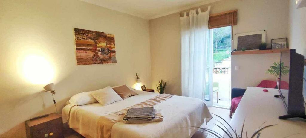 - une chambre avec un lit blanc et une fenêtre dans l'établissement Lovely Bedroom in Aljezur, à Aljezur