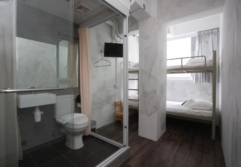 un letto e un bagno con doccia e servizi igienici. di Hop Inn a Hong Kong