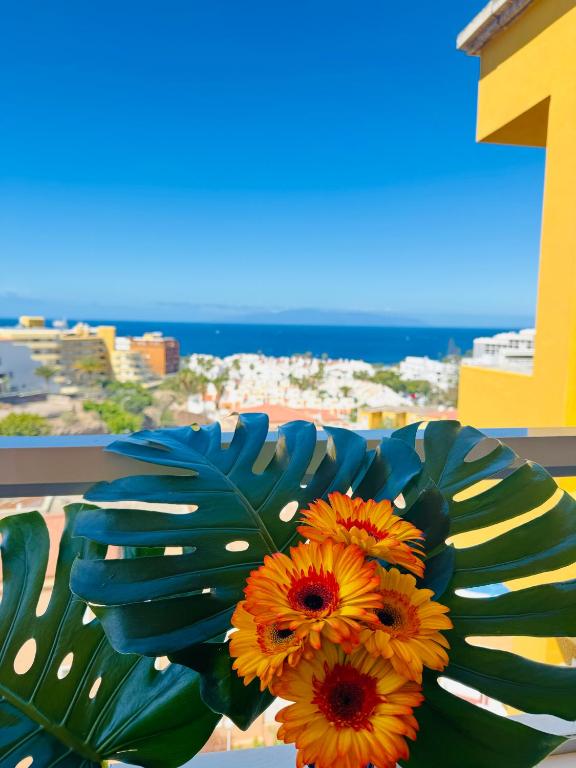 a bouquet of flowers sitting on top of a balcony at Costa Adeje Orlando Tenerife Sea View - Pool - AC in Adeje