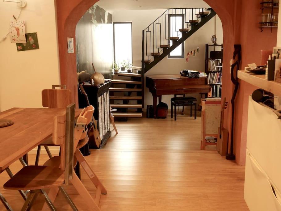 un salon avec une table et un escalier dans l'établissement Belle maison à Lagny, proche de Disney, à Lagny-sur-Marne