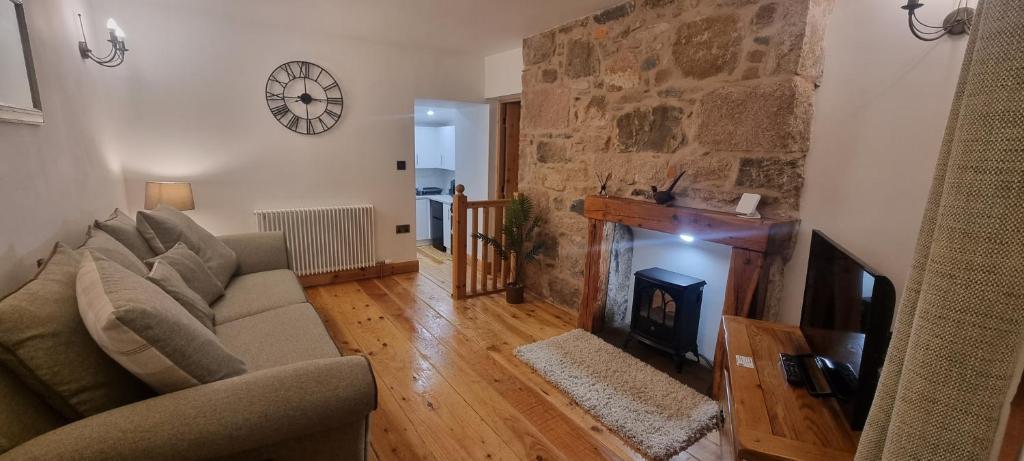 a living room with a couch and a fireplace at Coal Office Aberlour in Aberlour