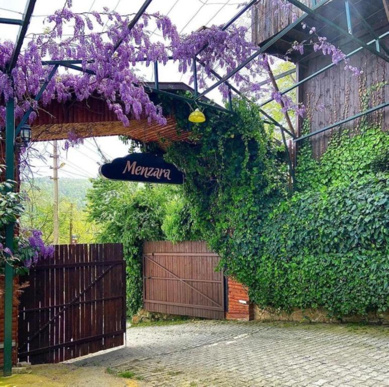 a sign that says meyer on a building with purple flowers at Menzara Hotel & Restaurant in Sapanca