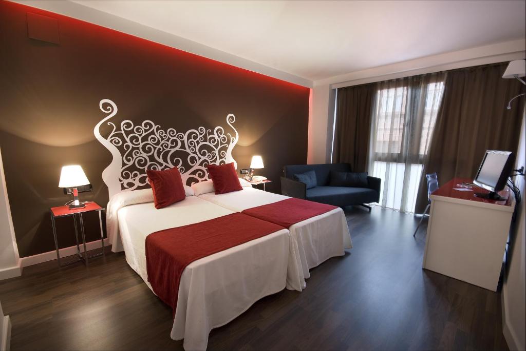 Un dormitorio con una cama grande con una pared roja. en Hotel Teruel Plaza, en Teruel