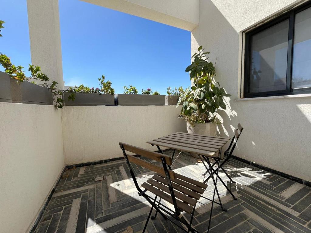 patio con mesa y sillas en el balcón en צימר אירוס ירוחם, en Yeruham