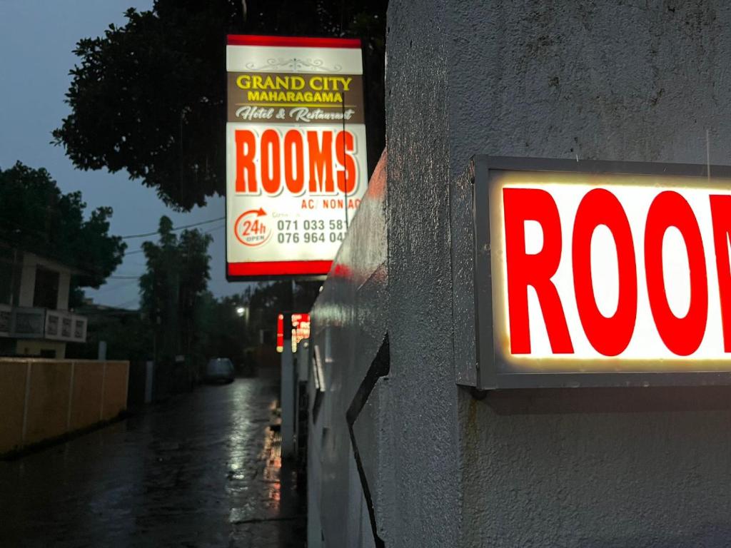 a sign on a wall with a roos sign on it at Sandarasi Inn Pvt ltd grand city in Maharagama