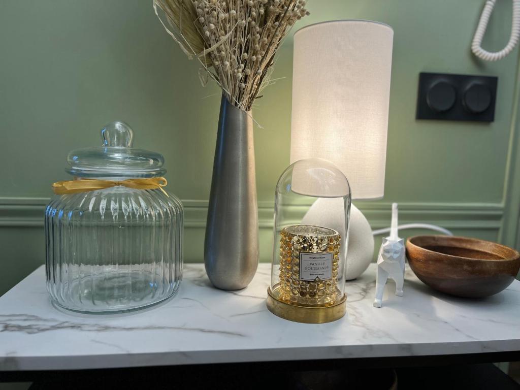 une table avec un bocal en verre et d'autres objets dessus dans l'établissement Appartement familial 6 couchages, à Nancy